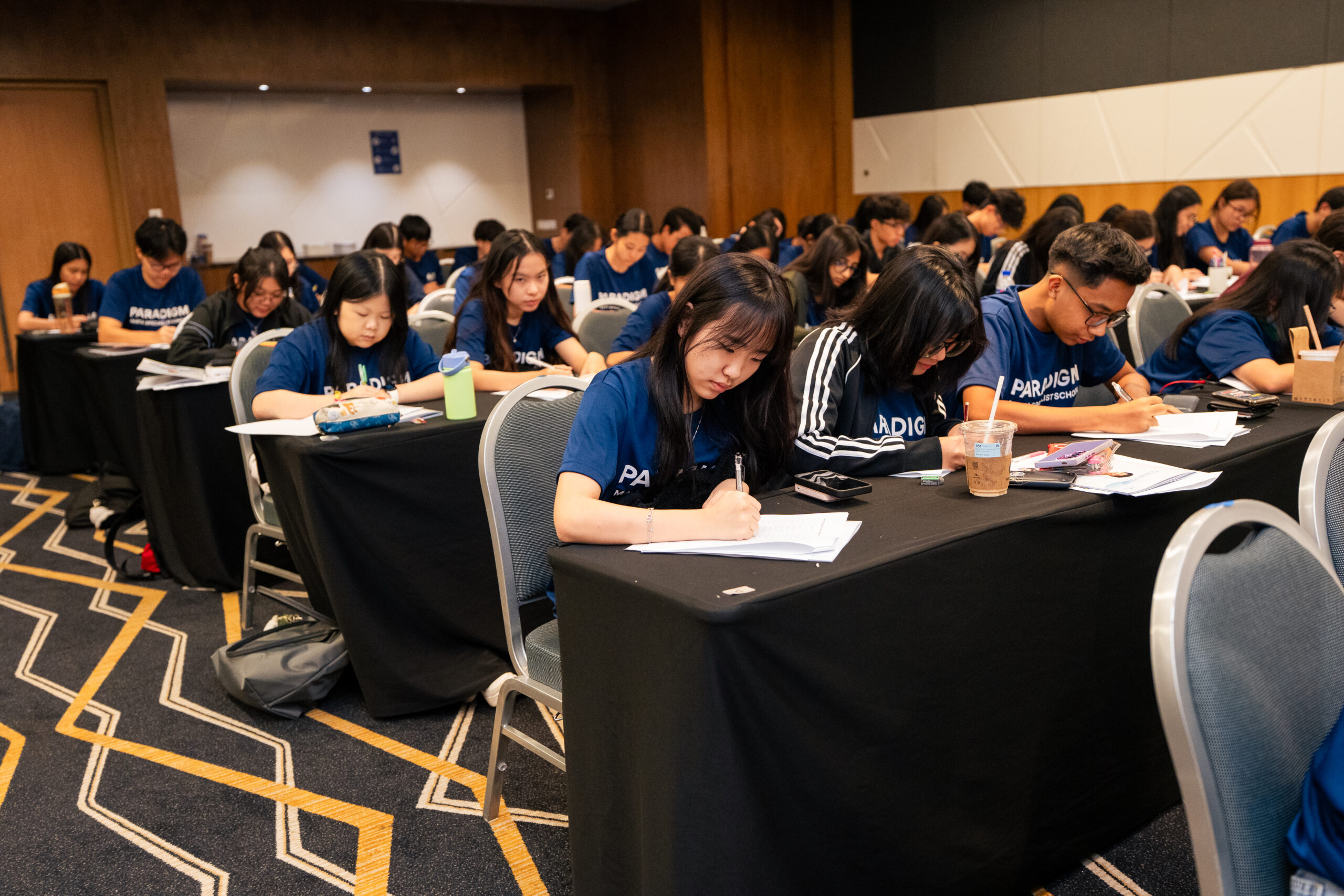 Paradigm students writing and focusing during an exam workshop activity